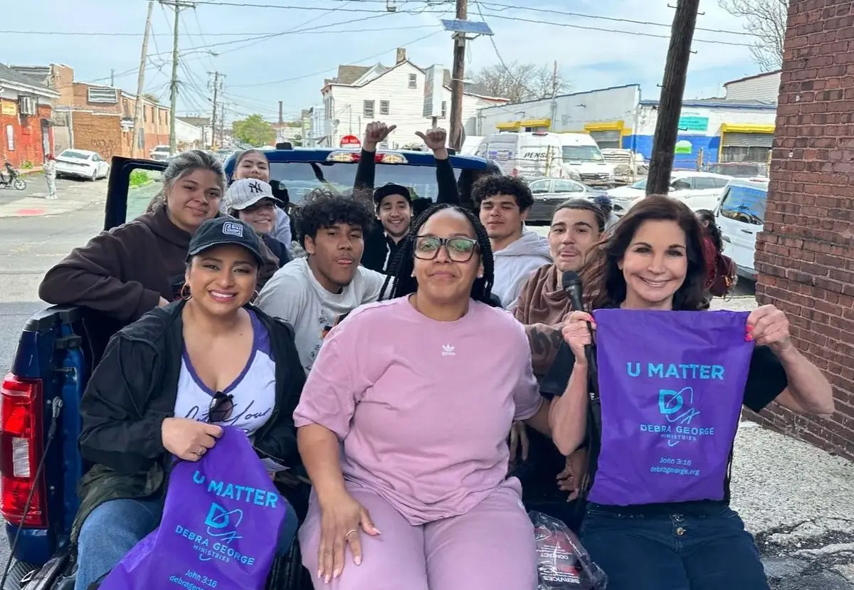 Volunteers smiling with purple U Matter bags